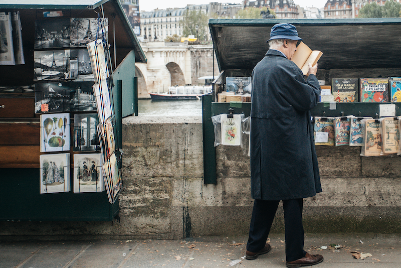 Un lecteur chez un bouquiniste des quais de Seine de Paris