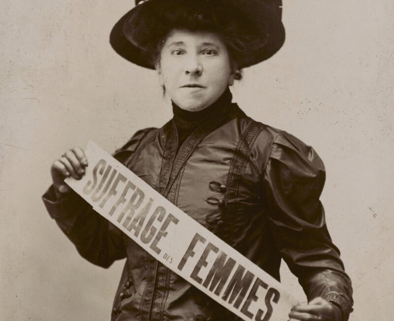 Hubertine Auclert tenant une banderole concernant le suffrage des femmes - © Bibliothèque Marguerite Durand