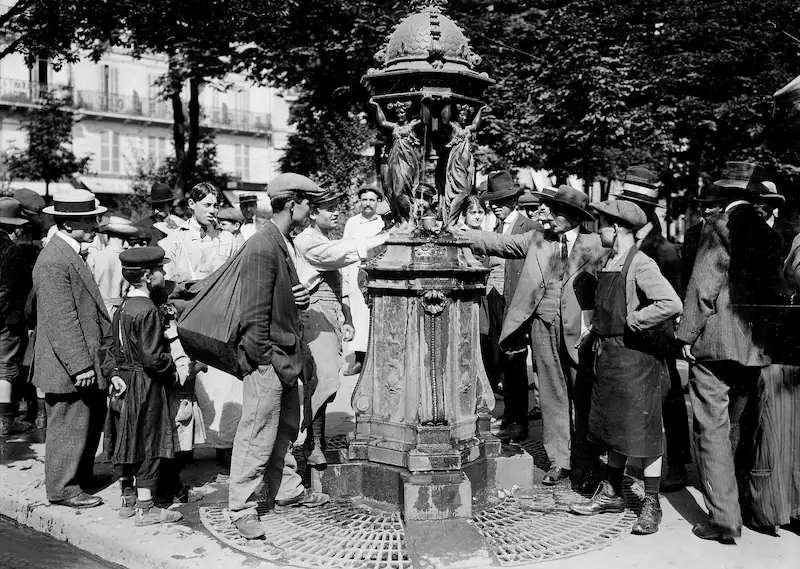 Photo d’archive de Parisiens se désaltérant à une fontaine © Maurice Branger / Roger-Viollet