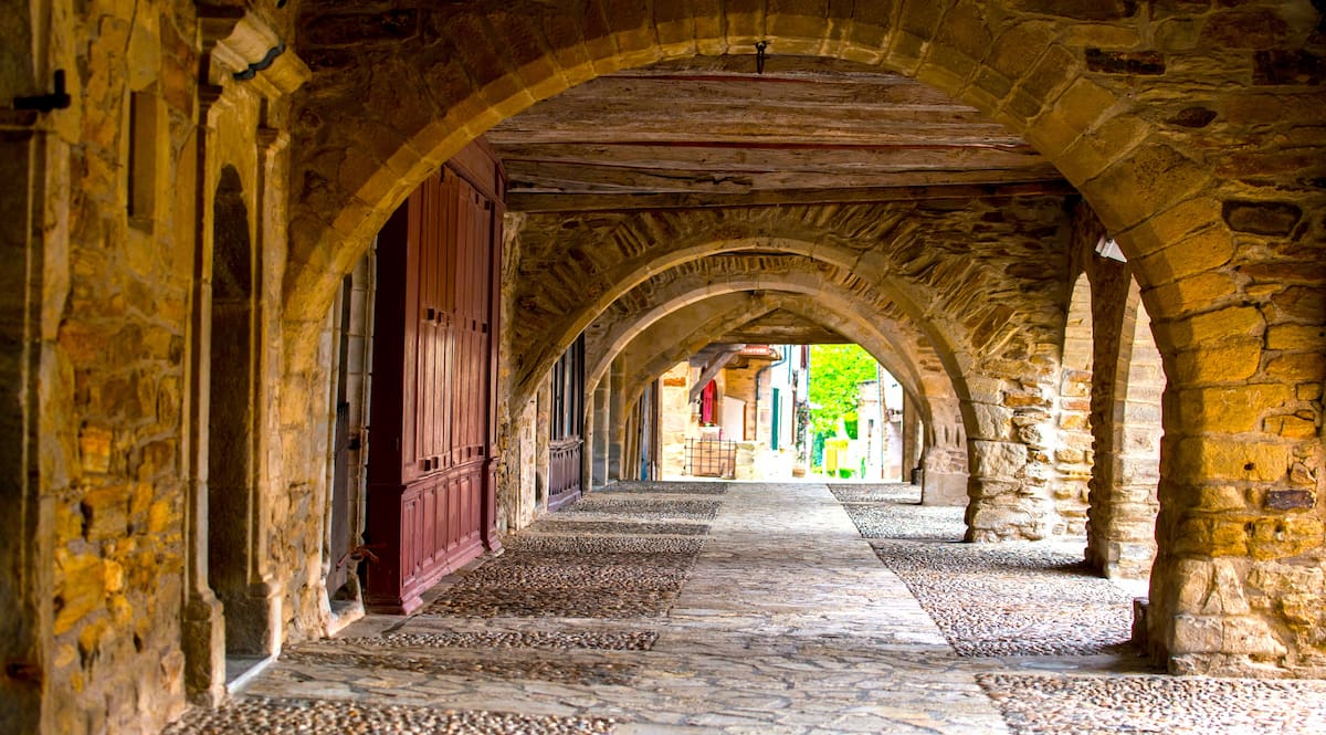 Arcades de la place centrale de Sauveterre-de-Rouergue © AdobeStock_ MIMOHE