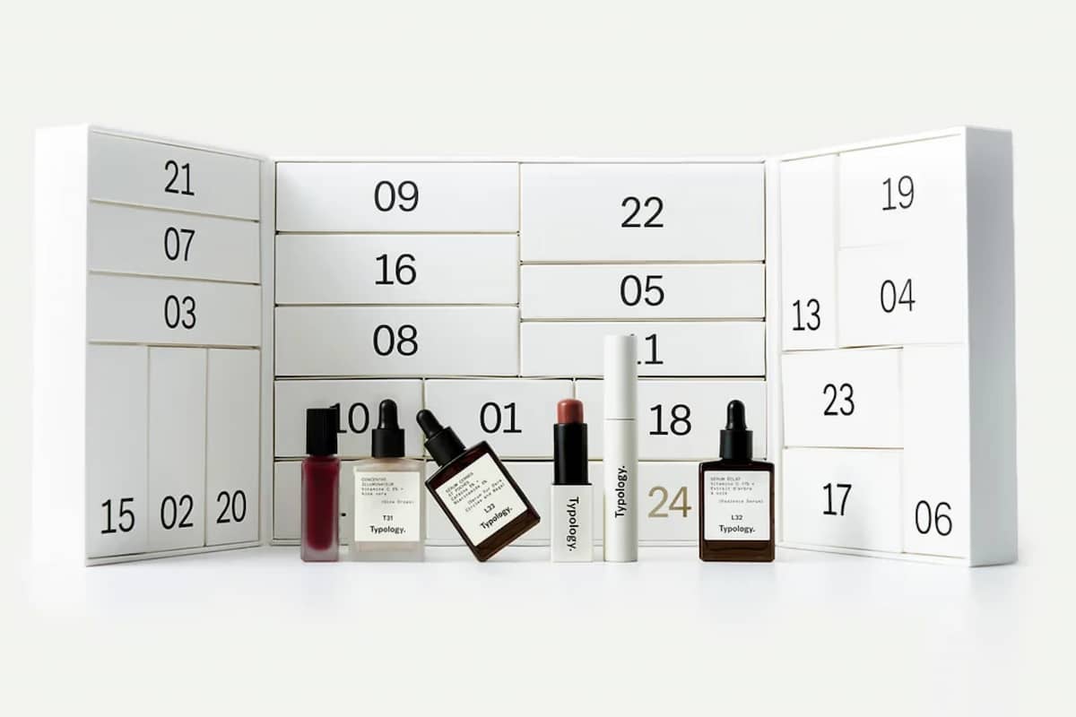 Calendrier de l'Avent Typology 2026 ouvert, avec ses 24 compartiments numérotés et plusieurs sérums et produits de soin.