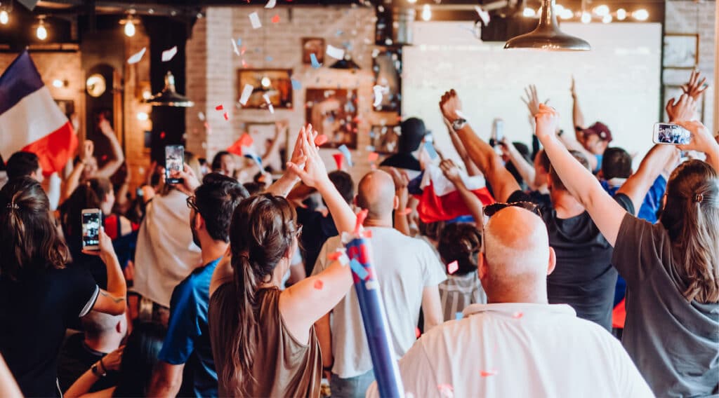 Supporters français devant un écran géant pendant un match de football