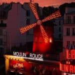 Moulin Rouge illuminé de nuit pour une séance de cinéma en plein air sur son rooftop