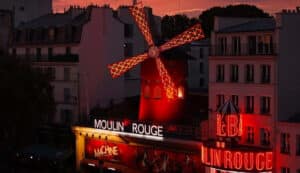 Moulin Rouge illuminé de nuit pour une séance de cinéma en plein air sur son rooftop