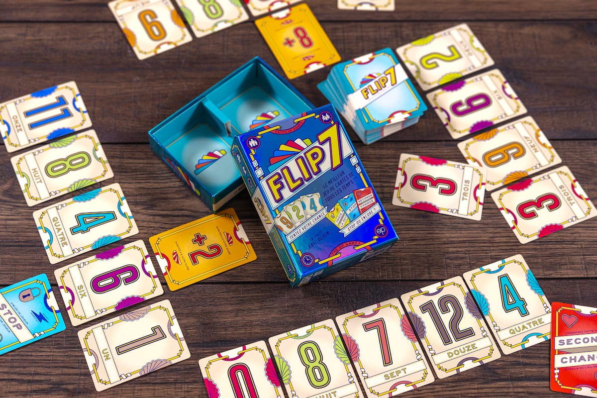 Cartes numérotées et cartes spéciales du jeu Flip 7 disposées sur une table pendant une partie.