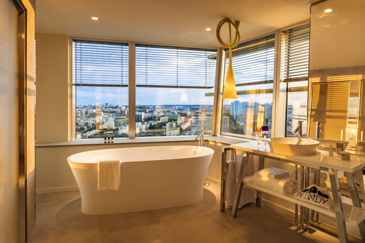 La salle de bains de la Junior Suite Tour Eiffel du TOO Hôtel Paris avec baignoire et vue sur la capitale