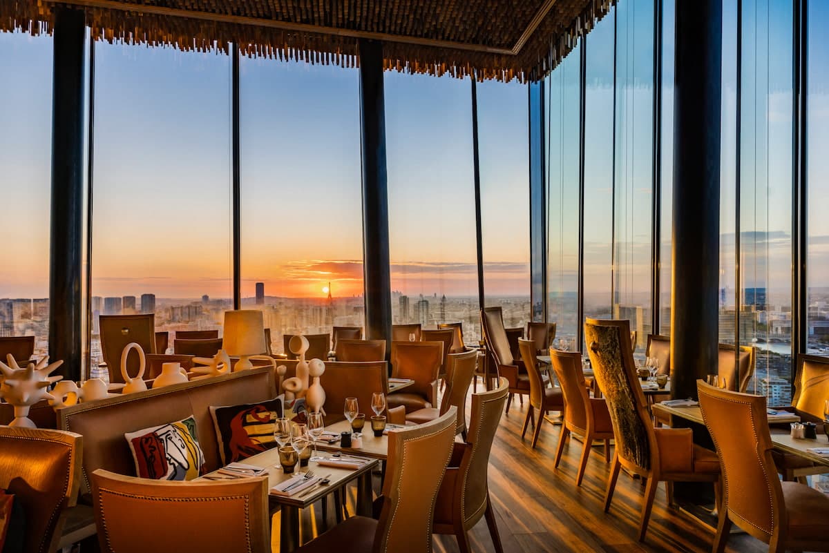 Le TOO Restaurant à Paris avec grandes baies vitrées et vue sur la tour Eiffel au coucher du soleil