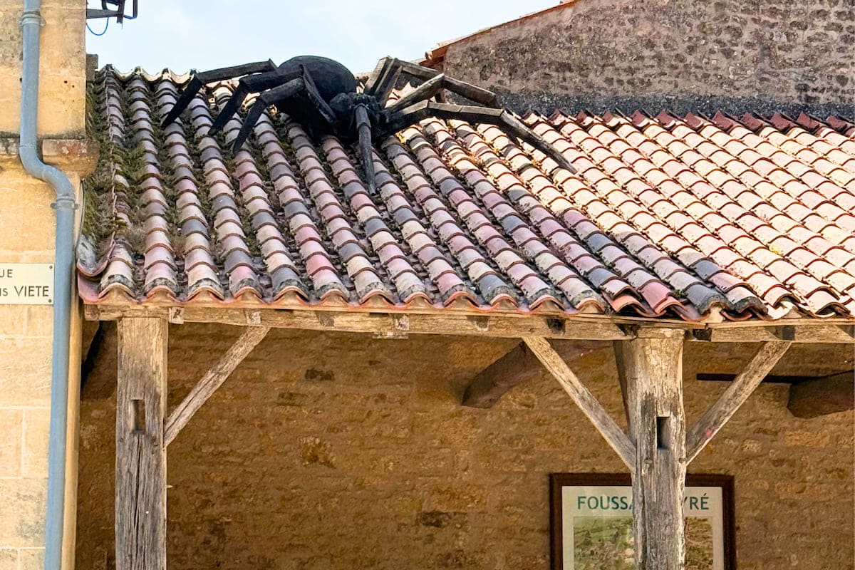 Araignée géante en bois sur le toit de la halle à Foussais-Payré