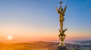 Statue dorée de l’archange Saint Michel au sommet du clocher de Saint-Michel-Mont-Mercure, face au bocage vendéen au lever du soleil