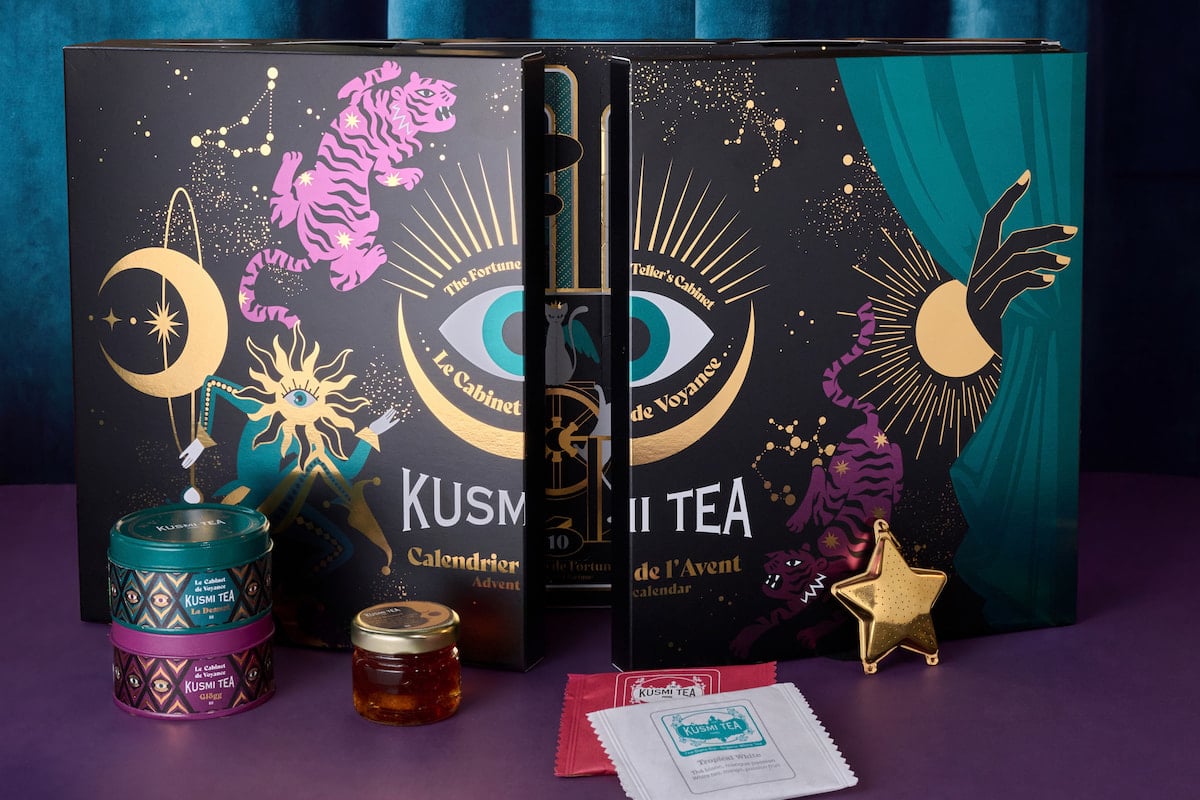 Calendrier de l'Avent Kusmi Tea 2026 aux motifs de tigres roses et dorés, entouré de thés, d'infusions et d'un infuseur étoile.