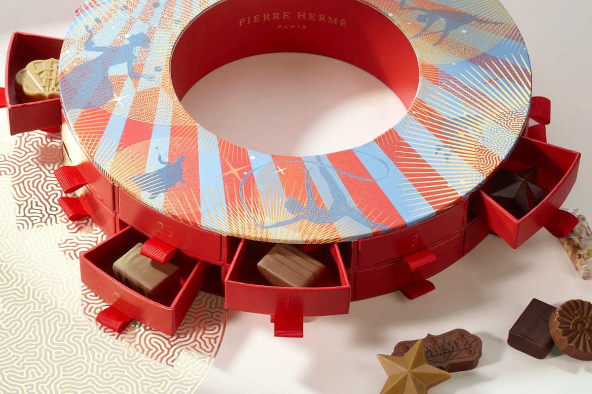Calendrier de l'Avent Signature 2026 de Pierre Hermé, en forme de couronne avec des tiroirs rouges remplis de chocolats.