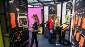 Des visiteurs jouent avec des dispositifs interactifs de l'exposition Cap sur l'IA au Musée de l'Air et de l'Espace du Bourget.